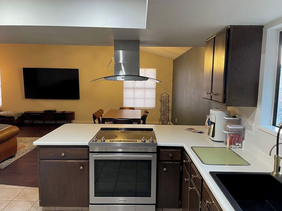 View through kitchen, into dining room, with view of TV; open and still together