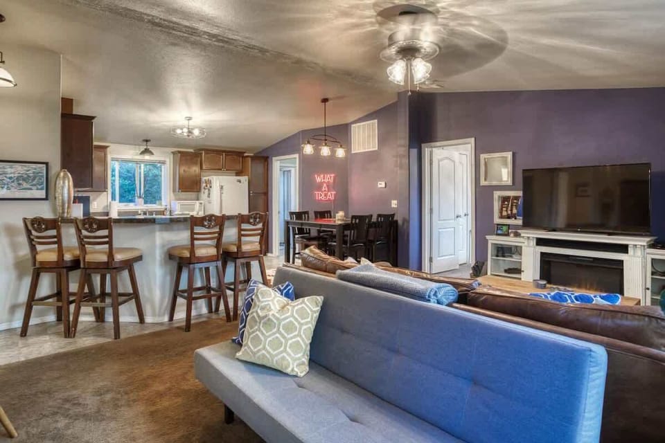 Beautifully furnished living area and kitchen with bar seating and dining table.