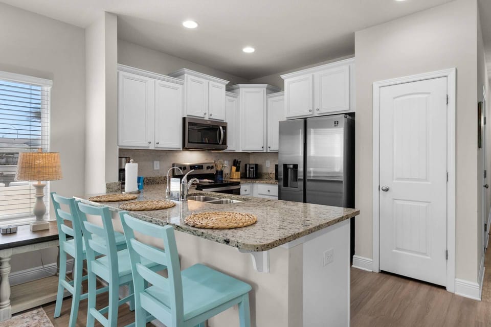 Fully equipped kitchen with bar seating for three.
