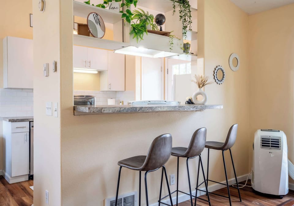 Fully stocked kitchen with bar seating and open shelving.