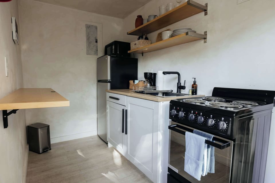 Kitchenette filled with all the necessities to prepare and cook a meal with a stove and oven, fridge and freezer and sink