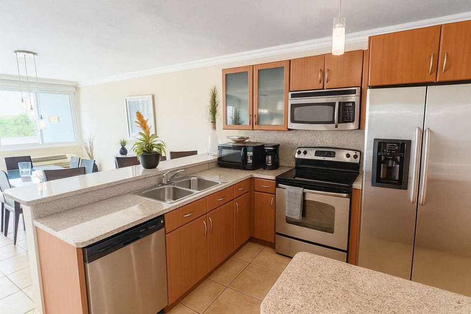 Beautifully equipped kitchen with stainless steel appliances and granite countertops — perfect for preparing meals while enjoying the open, airy layout of your stay.