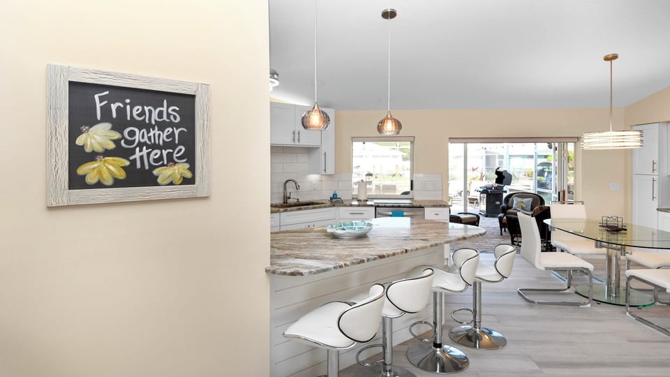 Open-plan kitchen with breakfast bar, modern pendant lights and inviting dining area – the social hub of the home