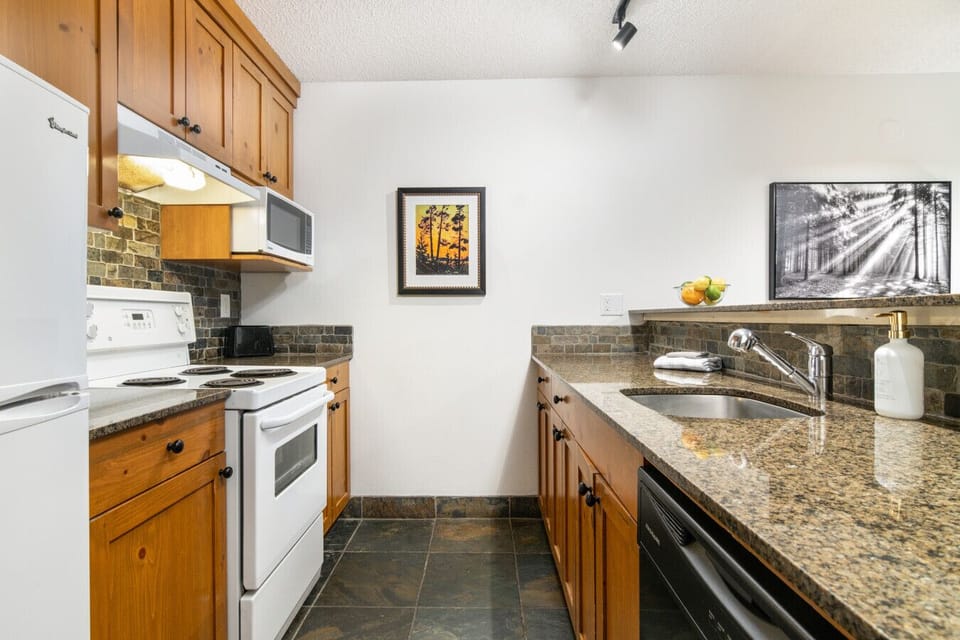 Fully equipped kitchen with oven, stove, fridge, microwave, and all utensils