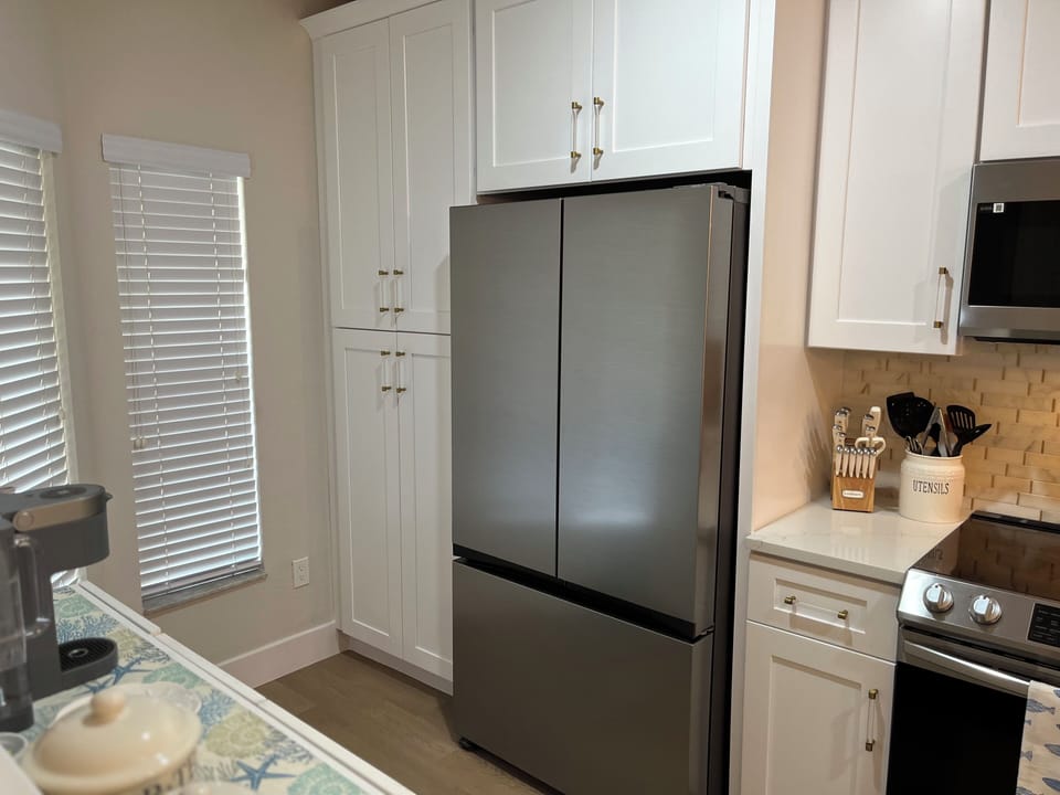 Newly remodeled kitchen with windows for lighting and blinds for privacy. Pantry
