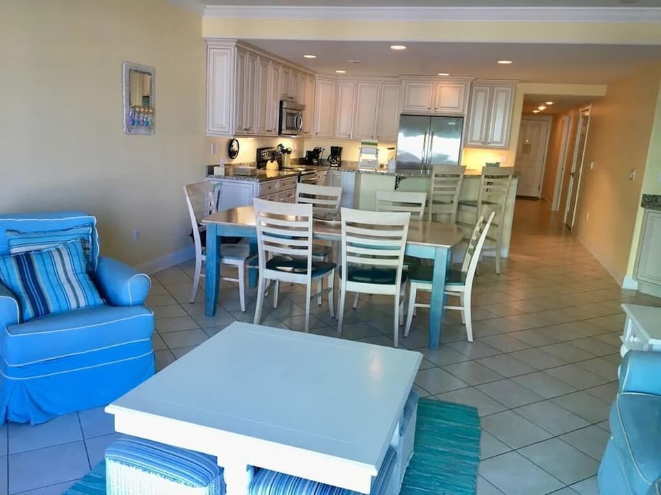 Gather around the dining table in this stylish condo, where beachy decor meets contemporary comfort, ideal for relaxing after a day in the sun.