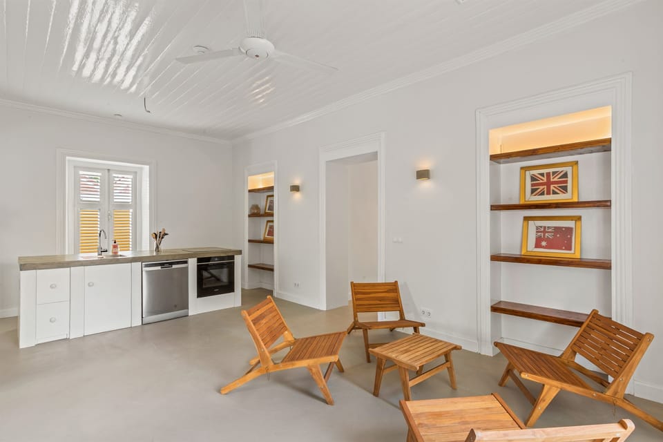 Bright kitchen and living area in Villa Grandi, Curaçao, featuring a sleek countertop, cozy sitting area, and seamless access to the private patio combining style, comfort, and indoor-outdoor island living in the heart of Otrobanda.