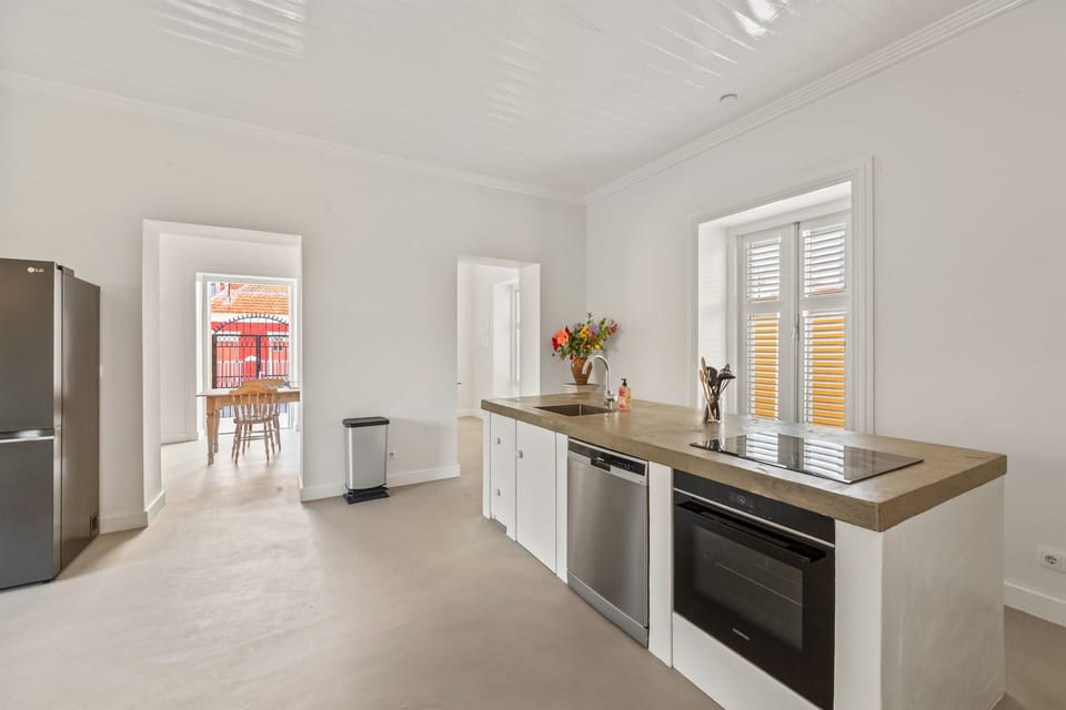 Bright open-plan kitchen and living space featuring a modern countertop, designer seating, and seamless flow to a charming private patio blending comfort, style, and Caribbean indoor-outdoor living in the heart of Otrobanda, Curaçao.