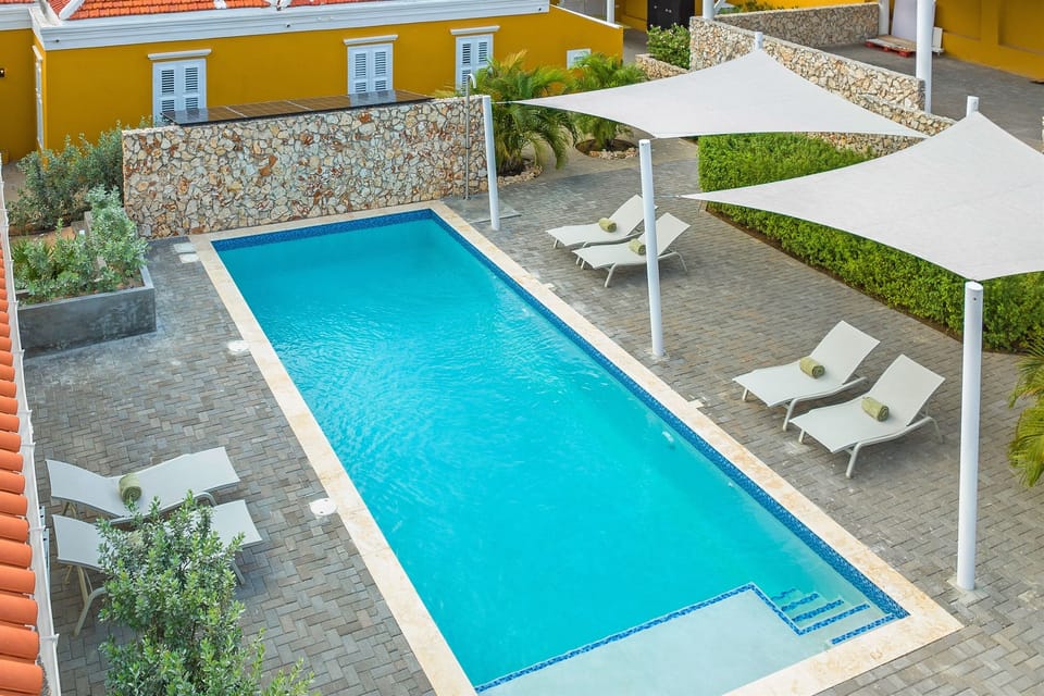 The 10×4 meter saltwater pool is the heart of Villa Grandi surrounded by tropical gardens and premium Fermob loungers, offering the perfect spot to relax and unwind in Curaçao’s sun.