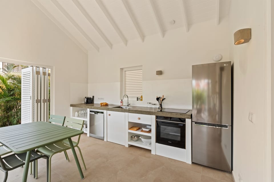 Villa Blenchi’s fully equipped kitchen features a Siemens dishwasher, induction cooktop, oven, LG fridge, and complete tableware perfect for preparing meals during your Curaçao stay in comfort and style.