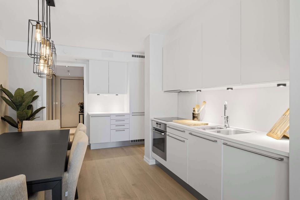 Sleek cabinetry, stovetop, oven, and a coffee maker.