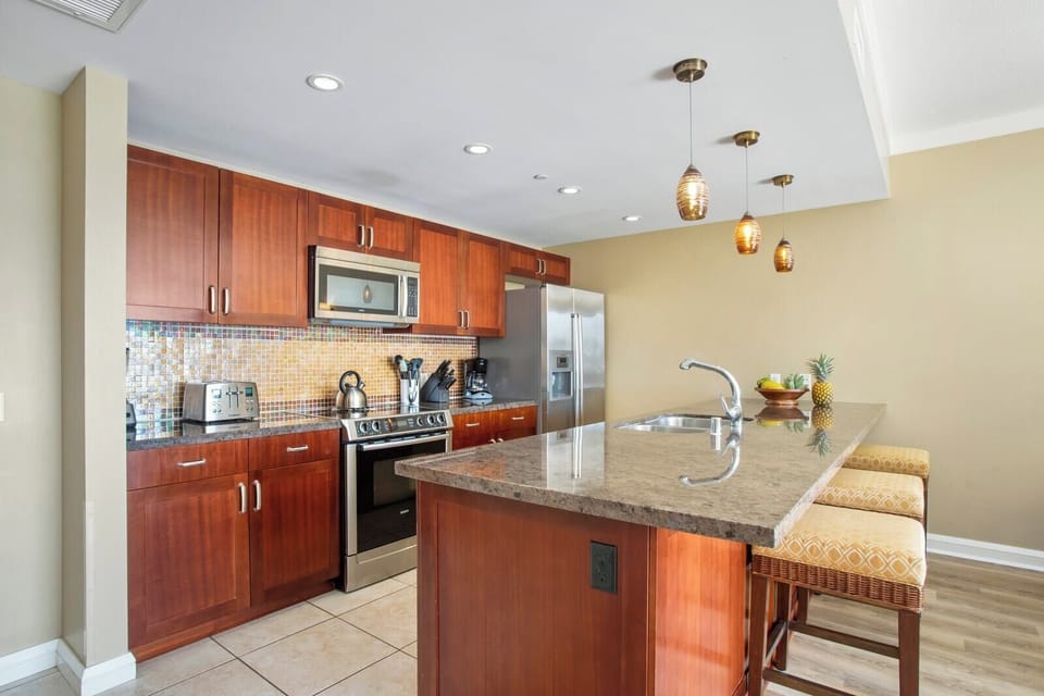 Sleek island kitchen with granite counters, pendant lights, and charm. HKK-229
