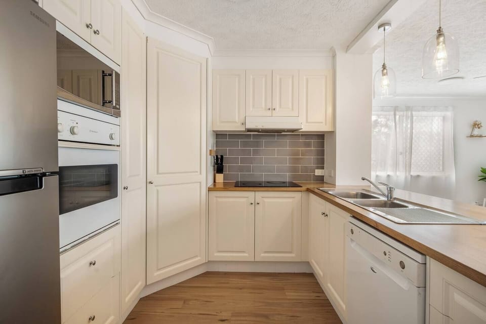 Prepare meals with ease in the warm, fully equipped kitchen, where modern appliances blend with relaxed coastal style, and everything you need is within reach.