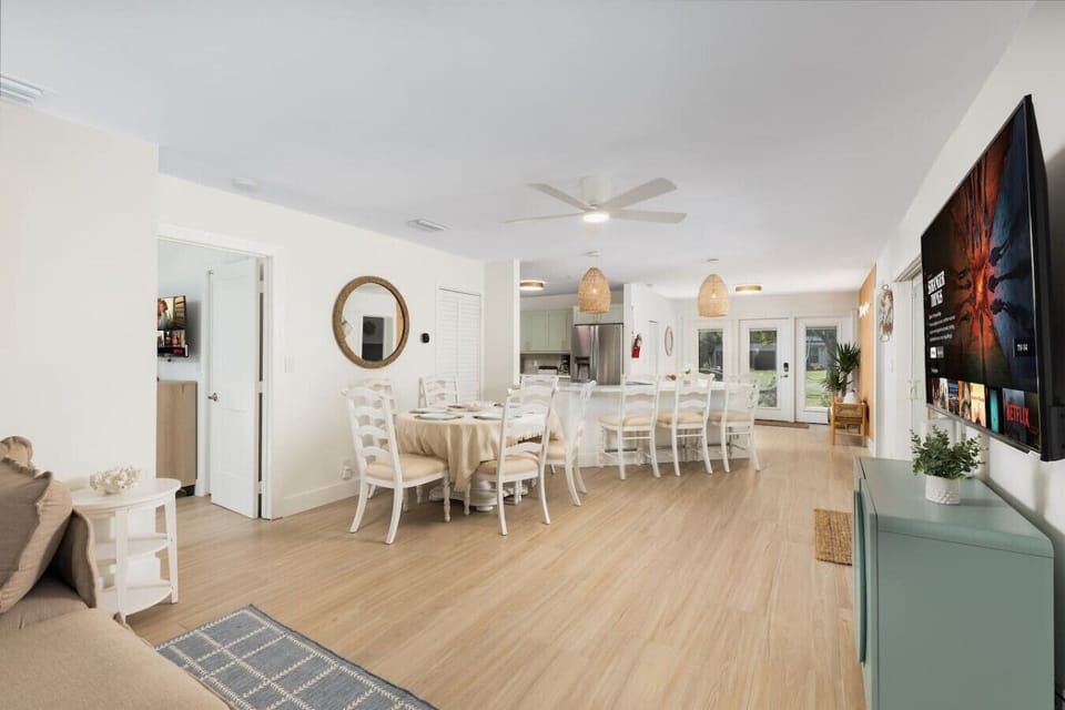 Open-concept living with dining table seating and barstools at the kitchen counter—great for shared meals, casual breakfasts, or relaxing together with the TV in view.