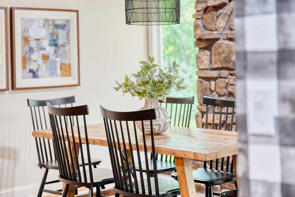 A thoughtfully designed table paired with elegant chairs and a vibrant vase of plants can transform any room into an inviting atmosphere.