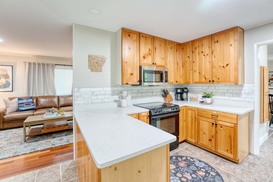 The rich texture of wooden cabinets paired with the sleek elegance of a stainless steel refrigerator creates an inviting atmosphere that enhances both functionality and style.