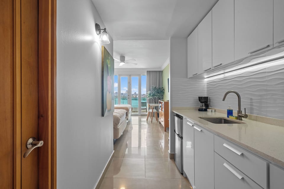 Sleek and functional: a bright white kitchenette designed for easy meal preparation during your stay.