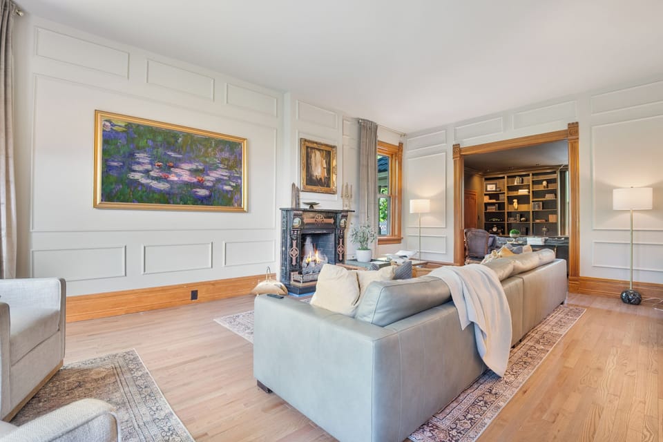 The massive parlor room with casement windows, gas fireplace, huge TV that serves as an art piece when not in use and oversized sofa with sitting area