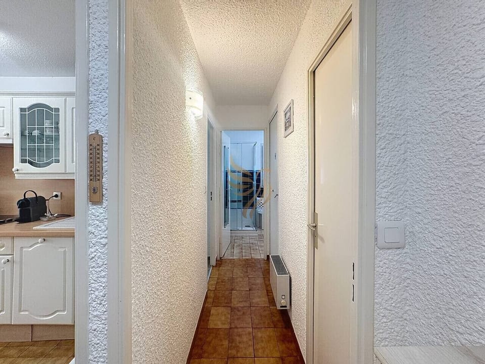Entrée et couloir desservant les différentes pièces du logement.