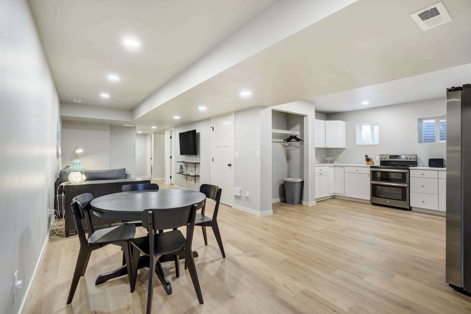 Spacious open-plan layout featuring a dining area, living space with Smart TV, and a fully stocked kitchen with stainless appliances.

