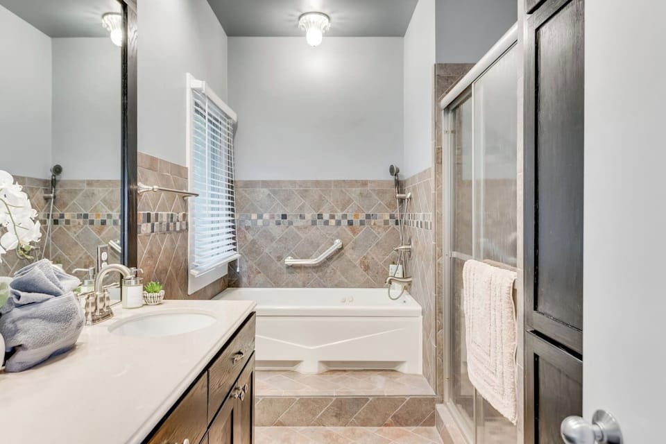 En-suite Bathroom 1: Indulge in luxury with a spacious tub and elegant fixtures for ultimate relaxation!