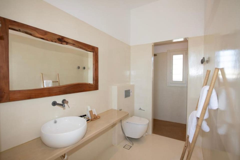 Bathroom with Walk-In Shower
Modern bathroom with rainfall shower, natural tones, and quality amenities.