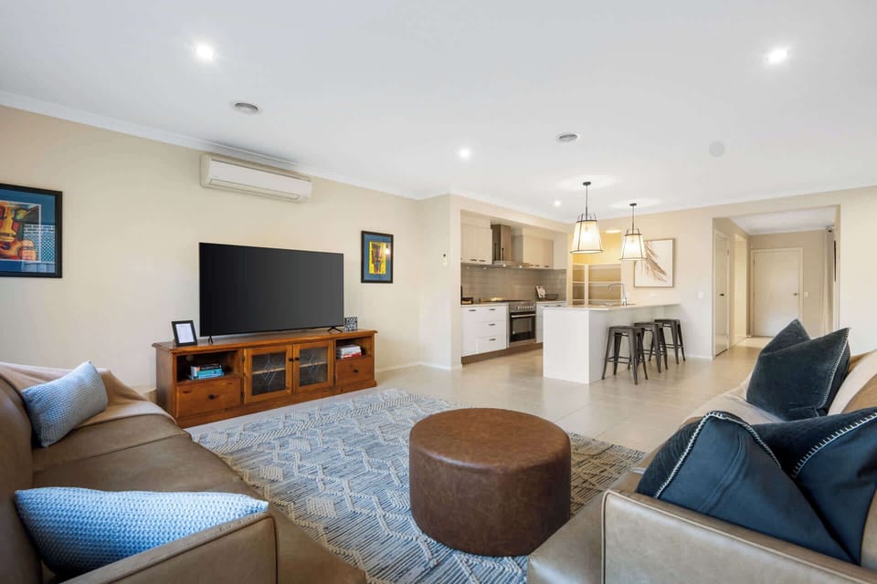 Main living area with flat screen TV, beautiful furnishings and direct access to the kitchen/dining and outdoor area.