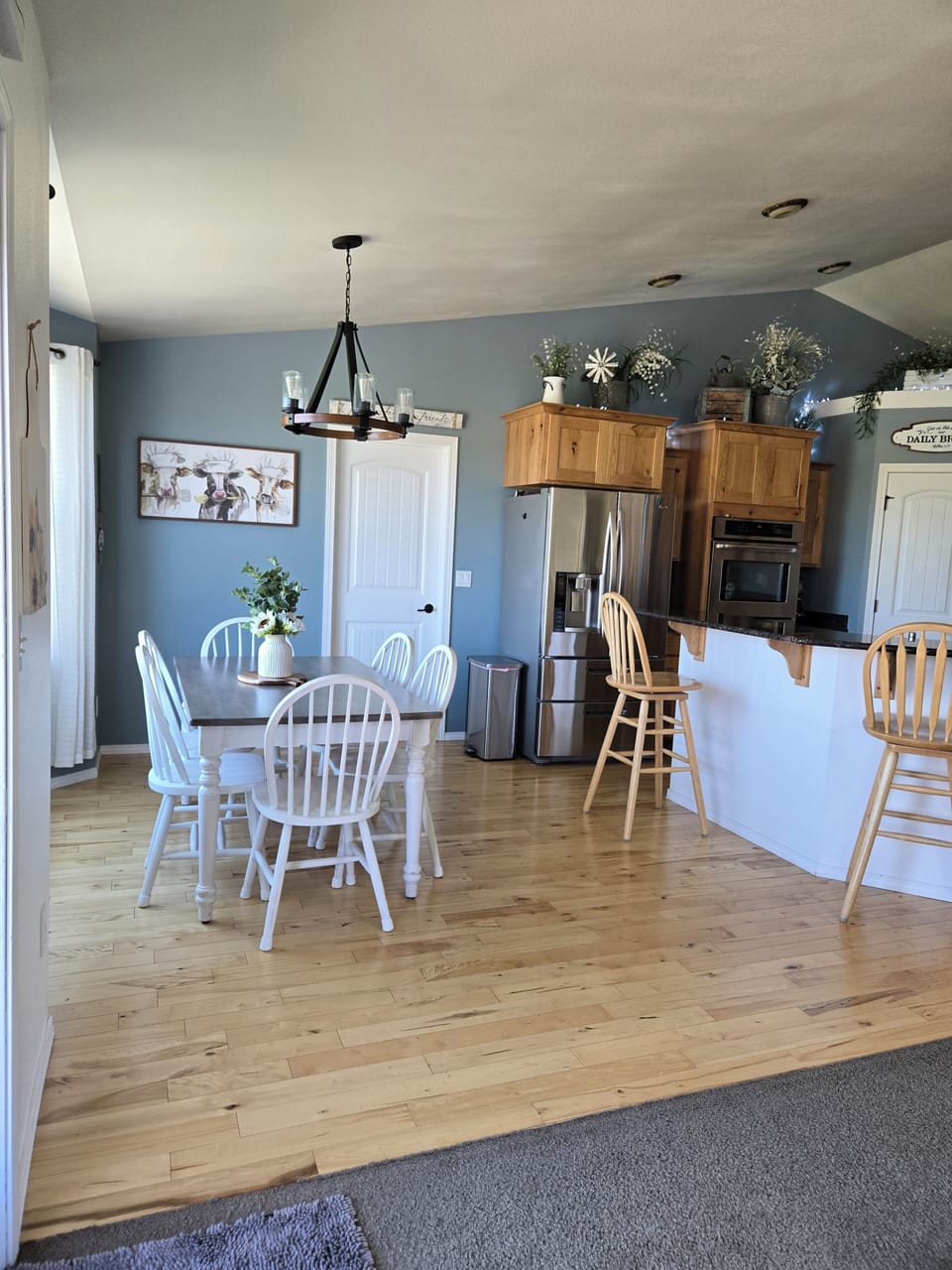 dinning room with 6 chairs at the table. 3 barstools at the counter. 