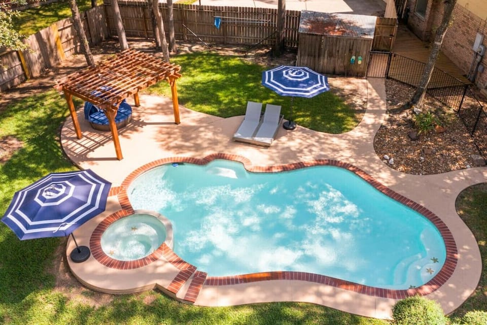 Aerial view of the heated pool and hot tub with pergola lounge — perfect for sunny afternoons and relaxing evenings
