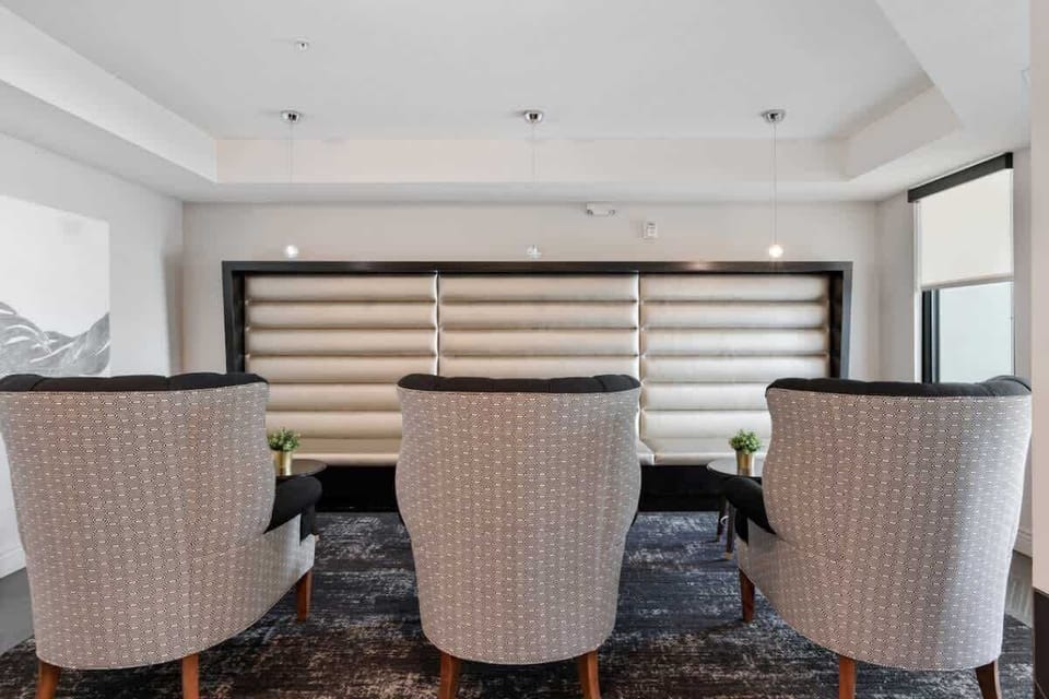 Unwind in a cozy living room with tree plants, soft sofas, and a TV for your entertainment.