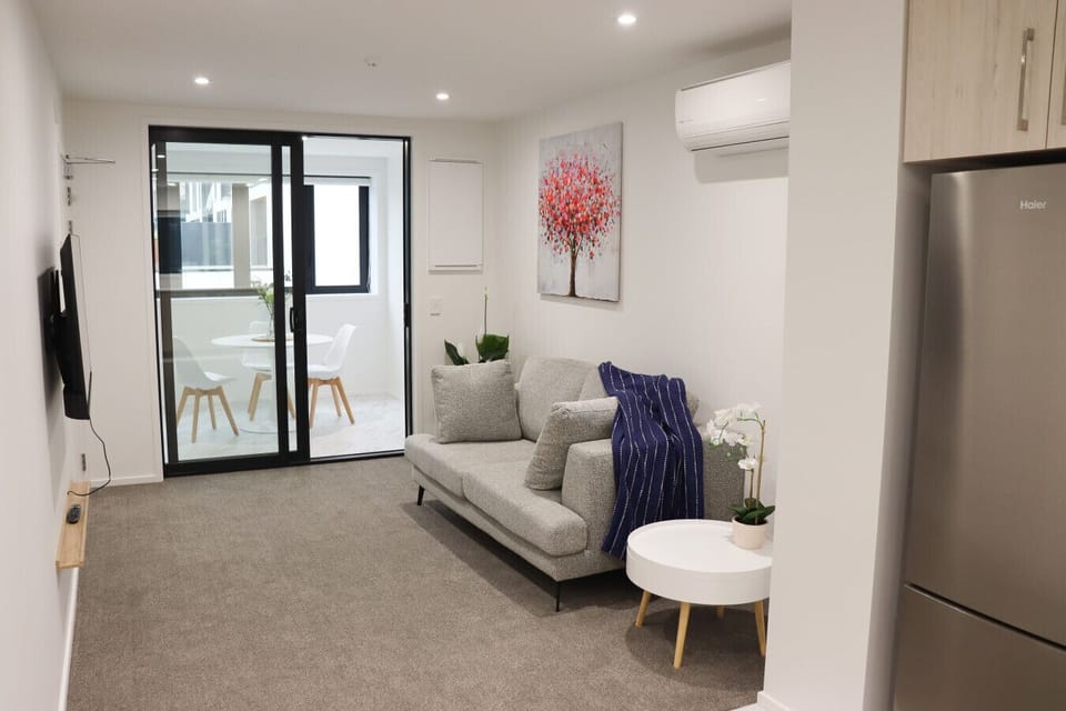 Spacious living area with a cozy sofa, stylish decor, and plenty of natural light—ideal for relaxing and unwinding.