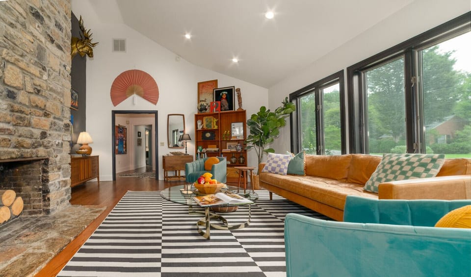 The spacious great room features vaulted ceilings, comfortable seating, a decorative stone fireplace and a record player!