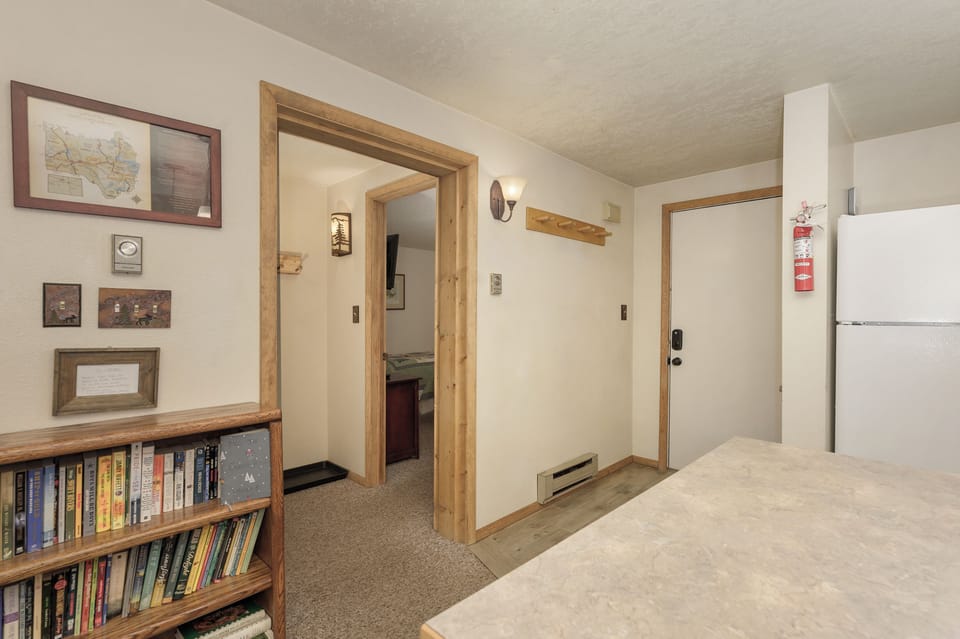 Cozy bedroom with rustic wood details, built-in bookshelf for evening reads, and thoughtful local touches on the walls.