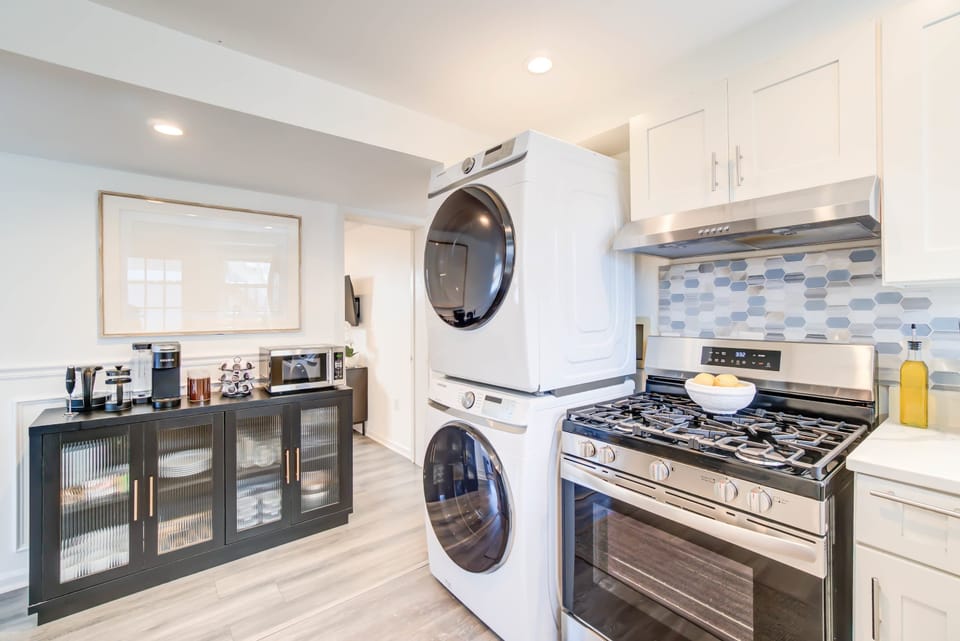  Fully equipped modern kitchen featuring a stove, premium cookware, blender, stainless 
steel sink with window views, and a stylish geometric tile backsplash—perfect for 
home-cooked meals. 