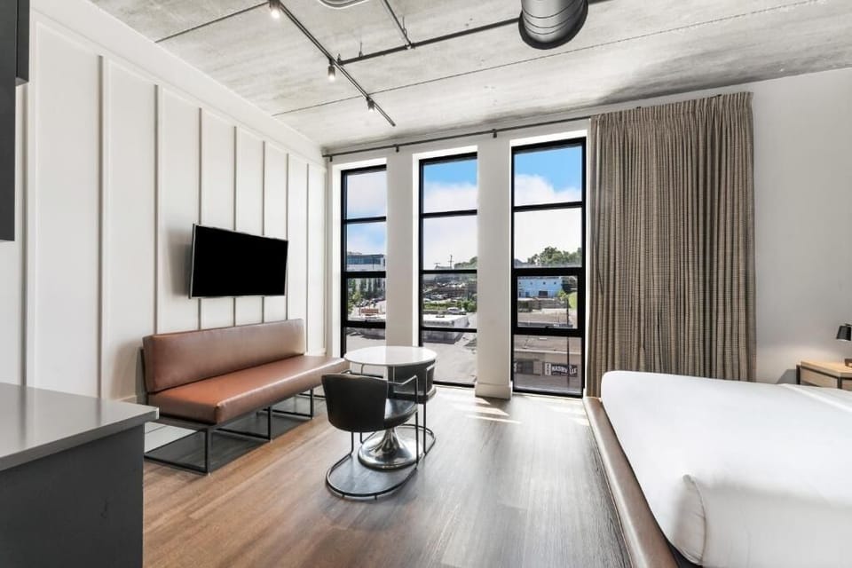 Sip morning coffee by tall windows in a bright suite.