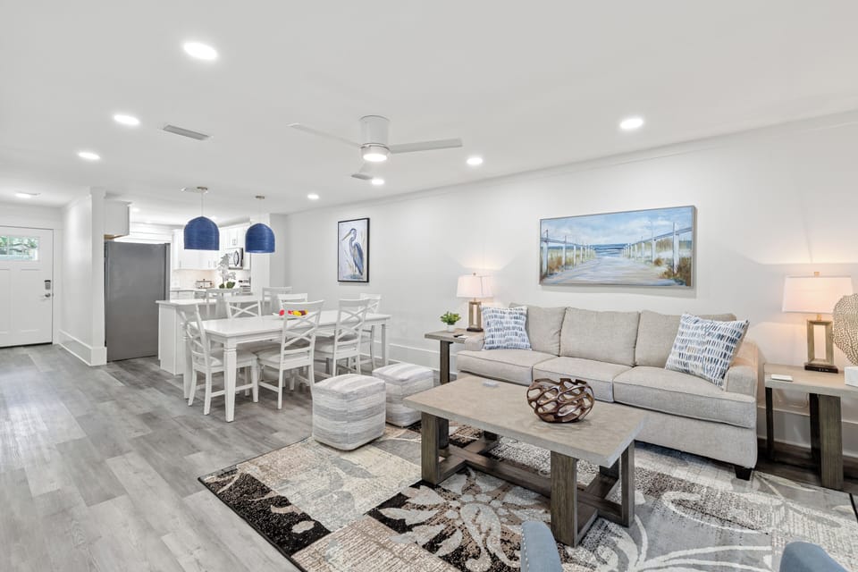 Relax in your bright living space featuring coastal decor, plush seating, and an open dining area perfect for family meals.