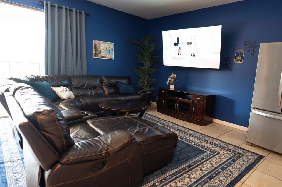 Family room with reclining sectional and big smart TV.