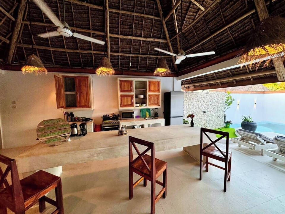 Open-air kitchen with long island, ceiling fans & private pool