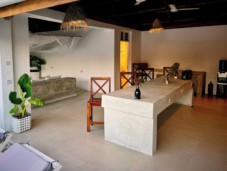 Airy tropical loft with concrete bar, canopy bed, coffee & water station