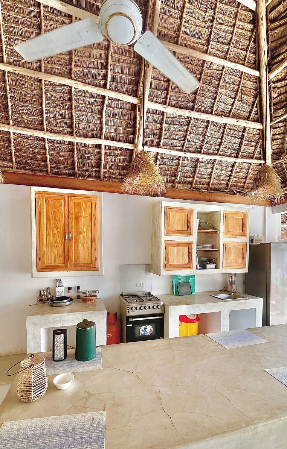 Airy palapa kitchen with concrete counters, gas range & breakfast bar