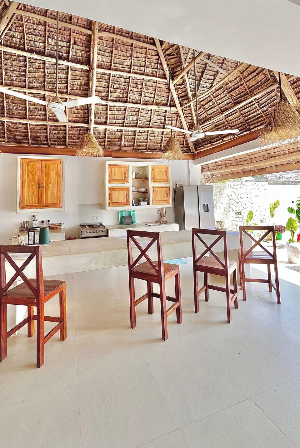 Open-air palapa kitchen with bar seating, fans & tropical vibes