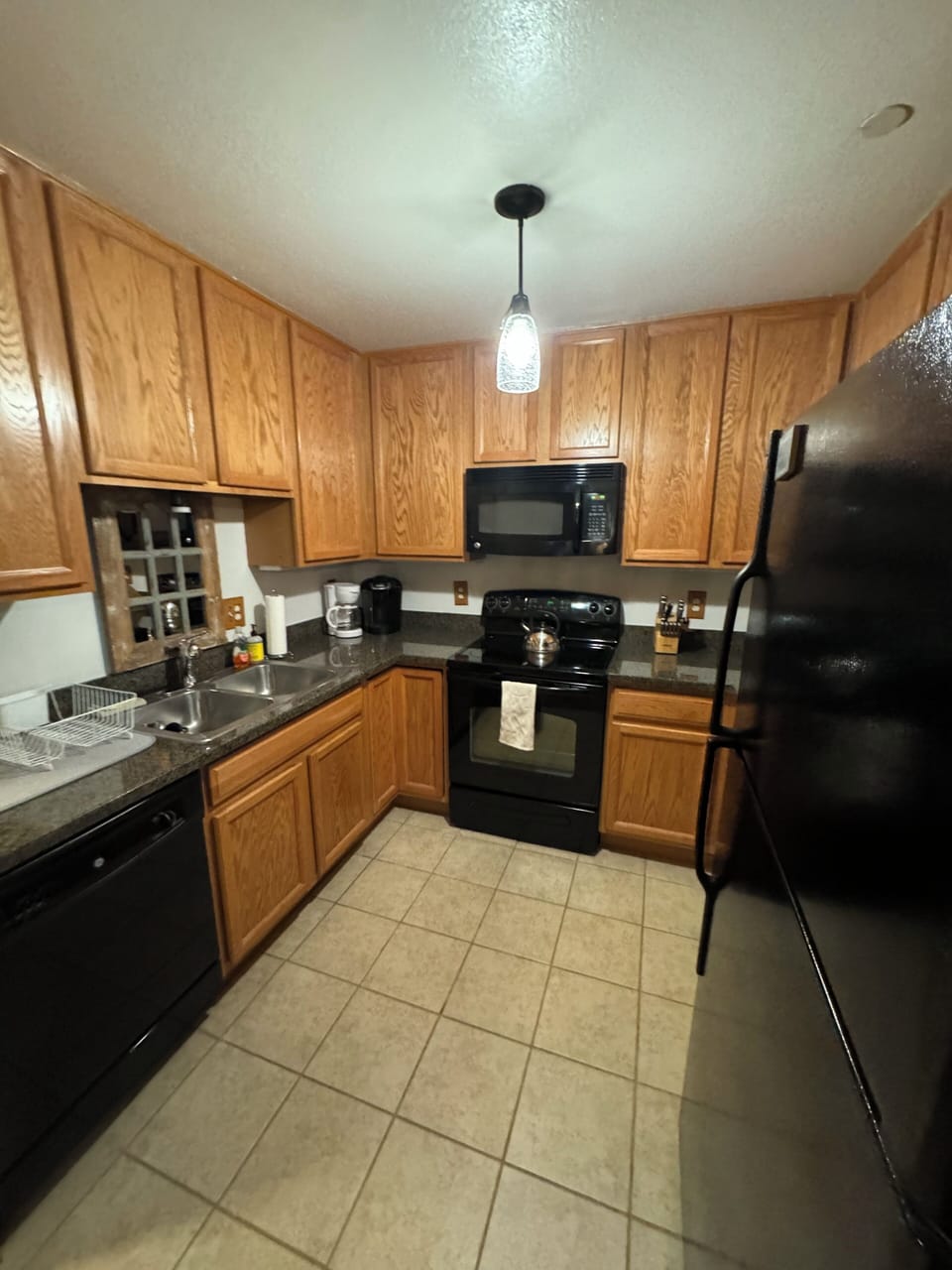 A full kitchen including a stove, microwave, refrigerator and dishwasher.