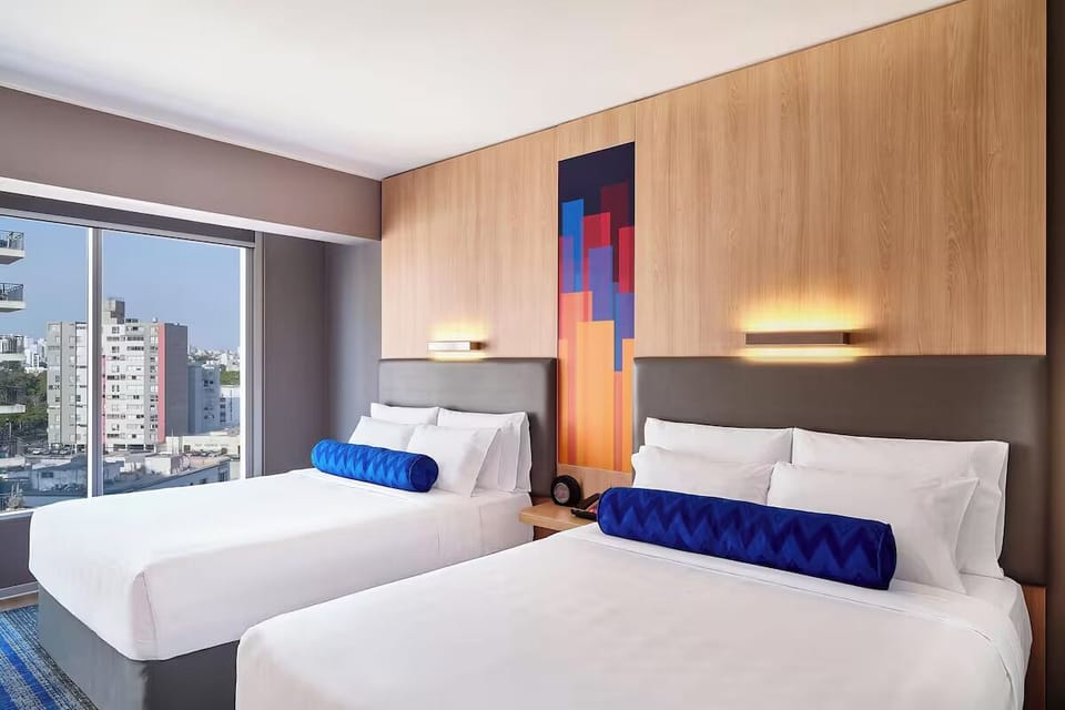 Stretch out in crisp linens under warm lighting and modern art.