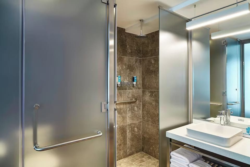 Refresh under a rainfall shower in a sleek, spa-like bath.
