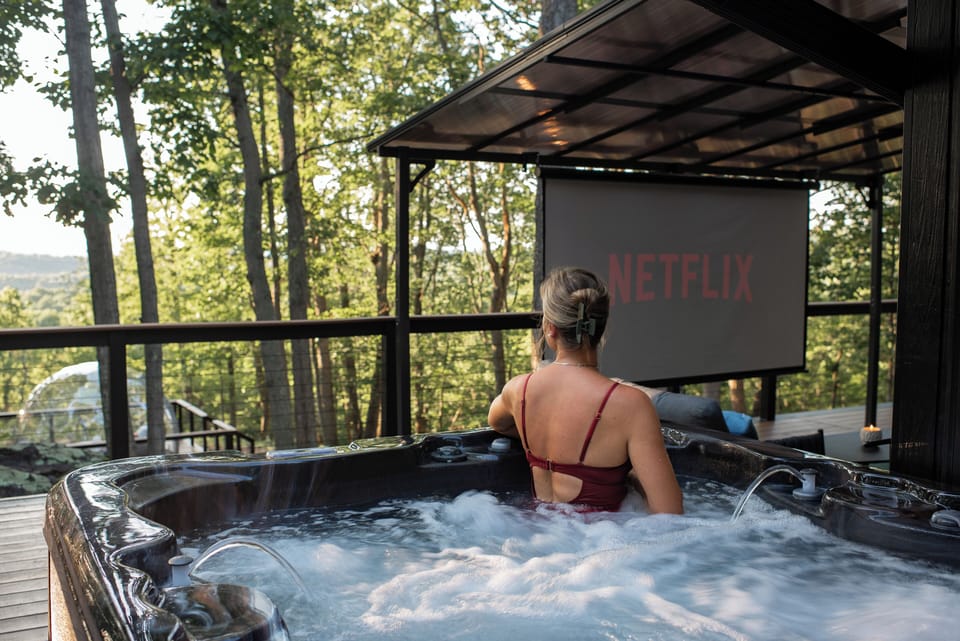 Soak in the serenity of your own nature spa retreat, where forest views, warm jets, and open-air cinema come together for the ultimate unwind.