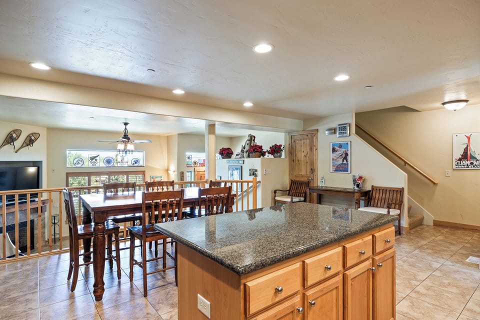 - Kitchen island with granite counters and wood cabinetry  
- Large dining table with bright natural light and cozy seating  
- Open-concept space perfect for family vacations and group stays