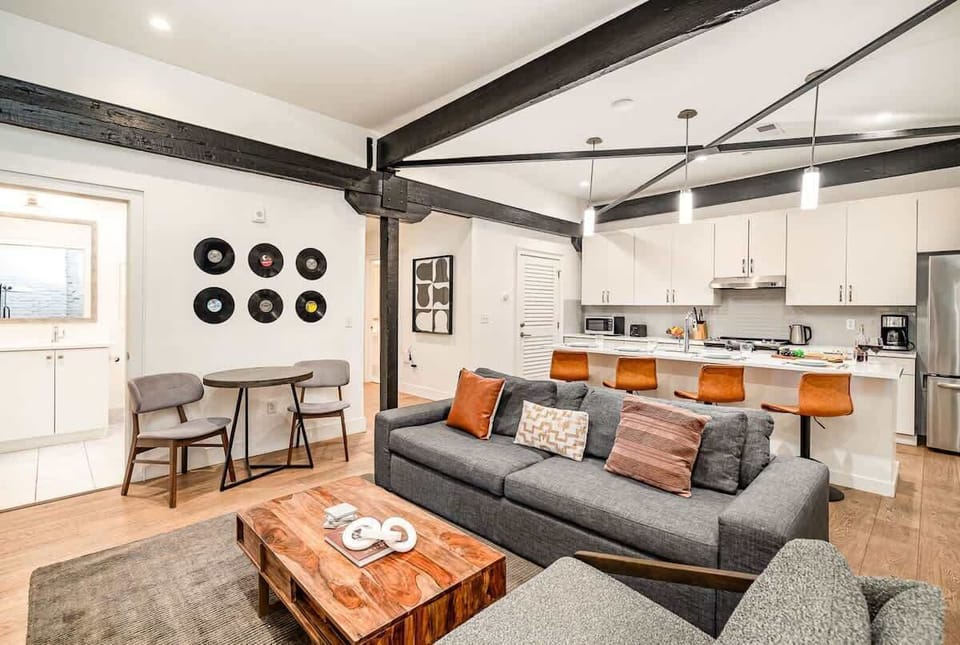 Living room with open-concept design featuring a white brick wall, Smart TV, and comfy sleeper sofa.