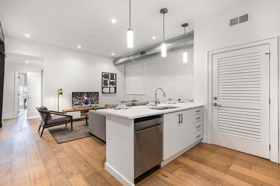 Unit 1: Fully equipped kitchen featuring stainless steel appliances, open counter space, and bar seating for 5 guests. (4th Floor)
