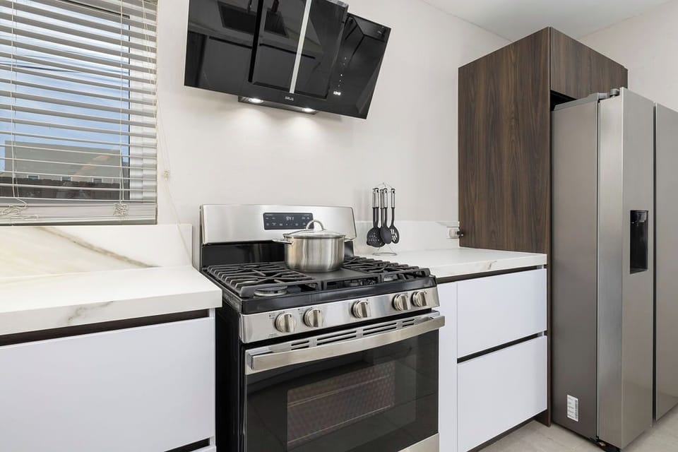 Fully equipped kitchen with gas stove, fridge, cookware, and modern finishes, cook with ease!