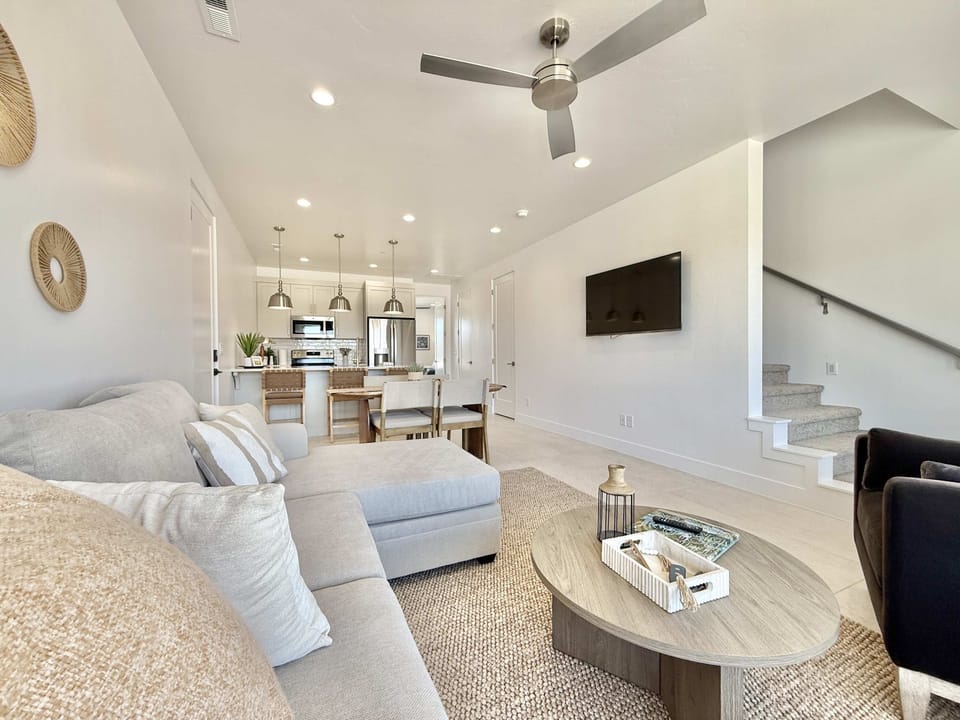 The living room, dining area, and kitchen are tastefully decorated with a comfortable couch, chairs, and designer decor